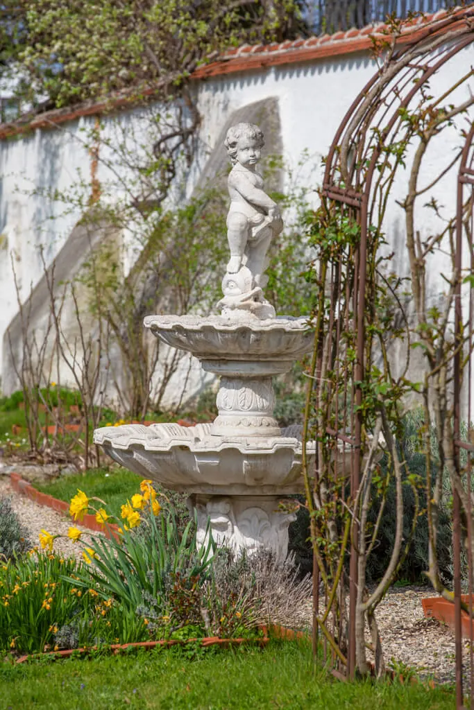 Brunnen und bepflanzter Gartenbereich im Innenhof des Rosenschlosses
