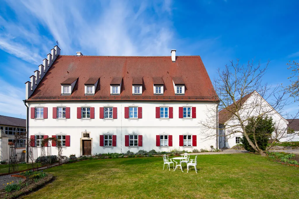 Rosenschloss Gundelfingen mit weißer Fassade und roten Fensterläden